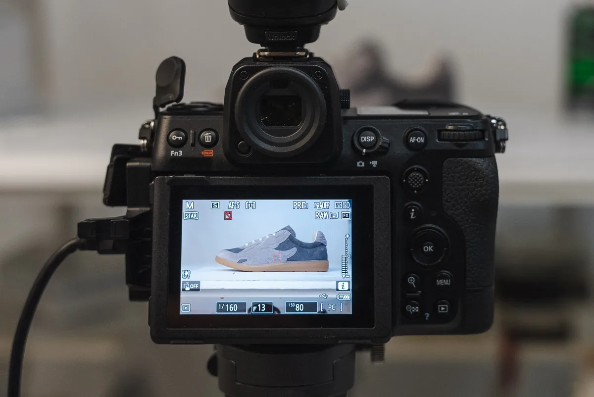 Behind the Scenes – Kamera-Display zeigt Sneaker-Aufnahme mit Belichtungseinstellungen